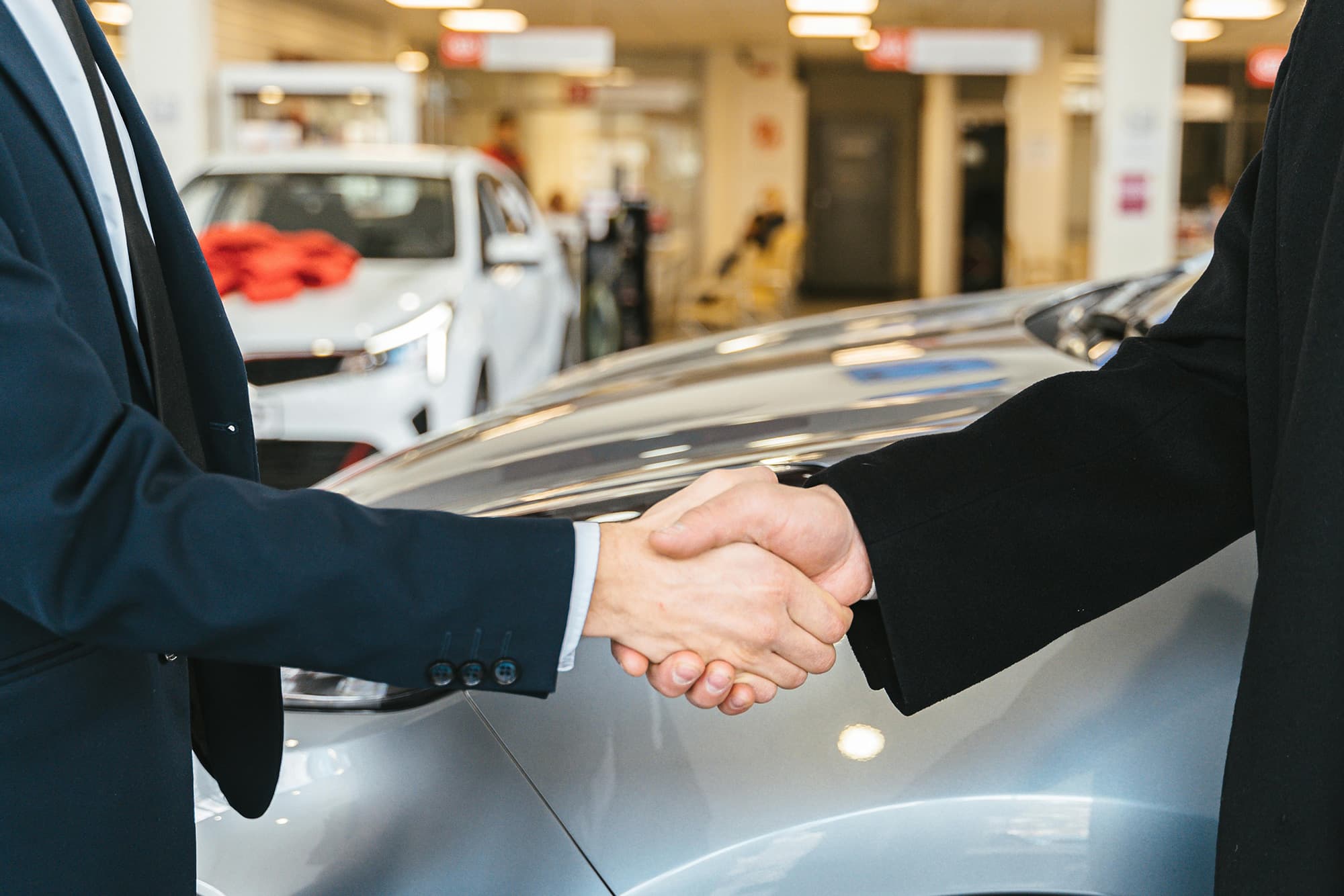 Men shaking hands at car dealer