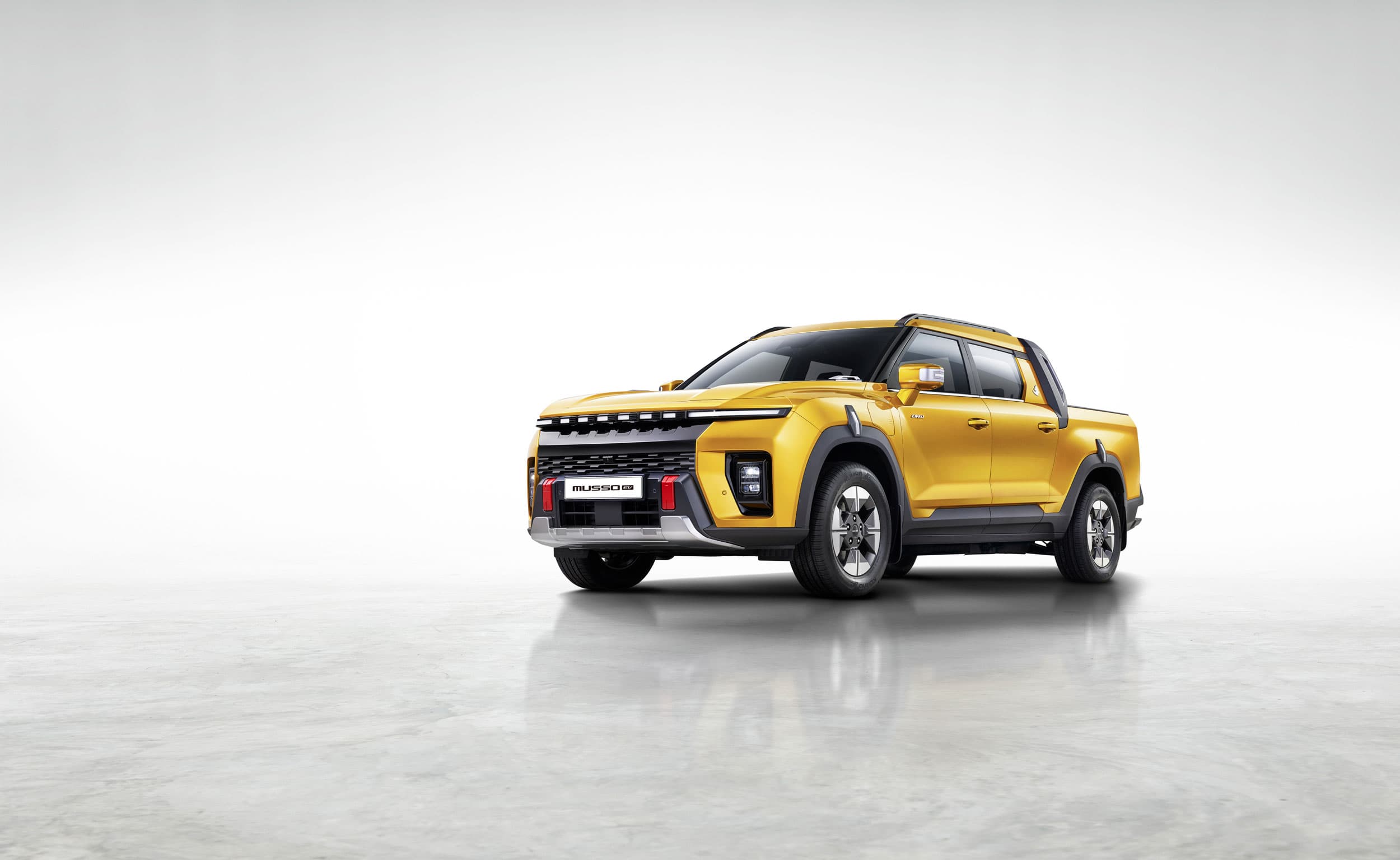 KGM Musso EV yellow left side view