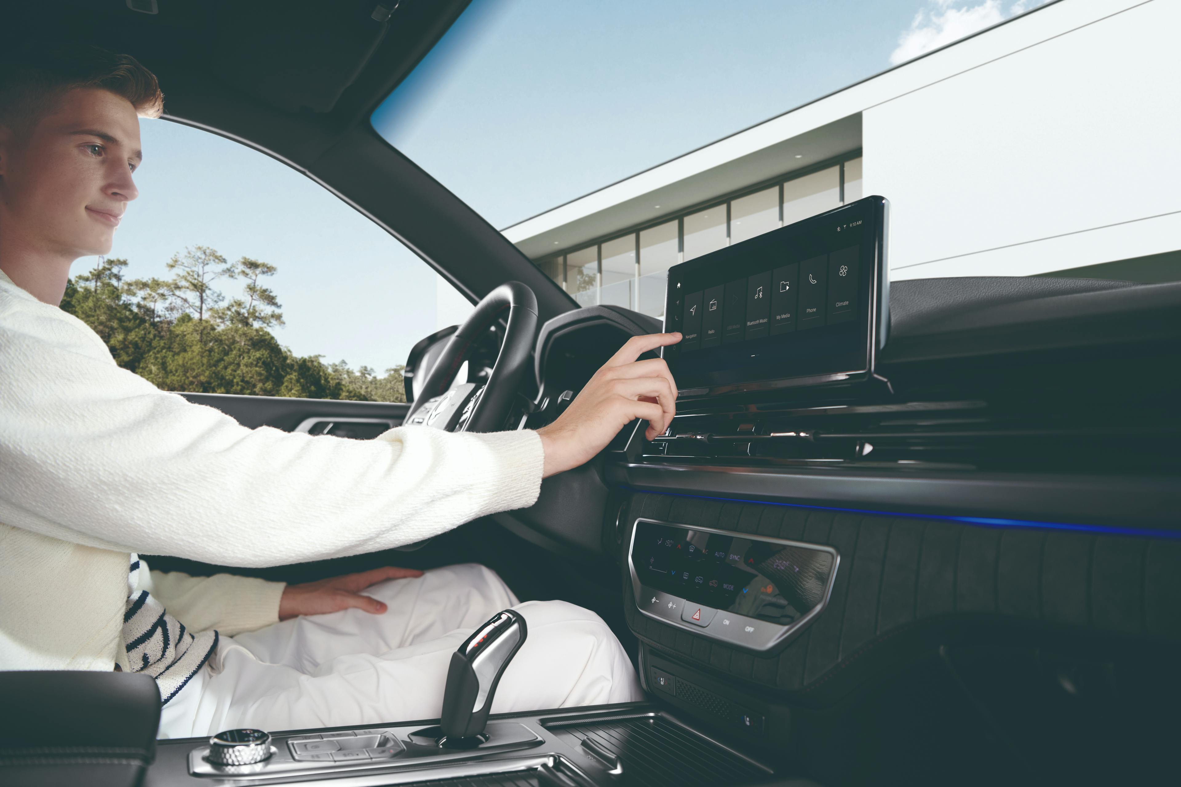 Een man in witte kleding die op het HD-aanraakscherm van de Rexton SUV bezig is.